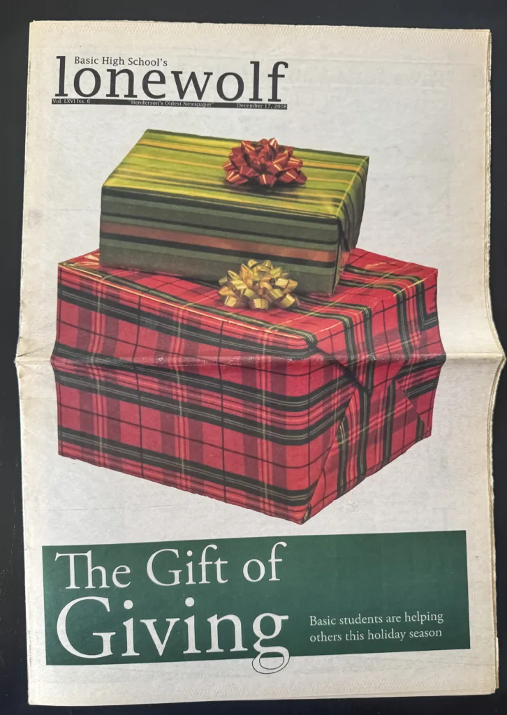 Front page of Basic High School's "Lone Wolf" newspaper from December 17, 2008, featuring a stack of three wrapped holiday gifts in red, green, and gold plaid. The headline at the bottom reads "The Gift of Giving" in large white script.