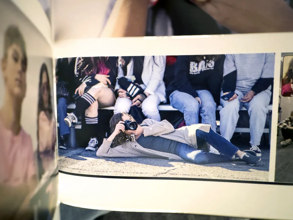 A woman lying down taking a photograph.